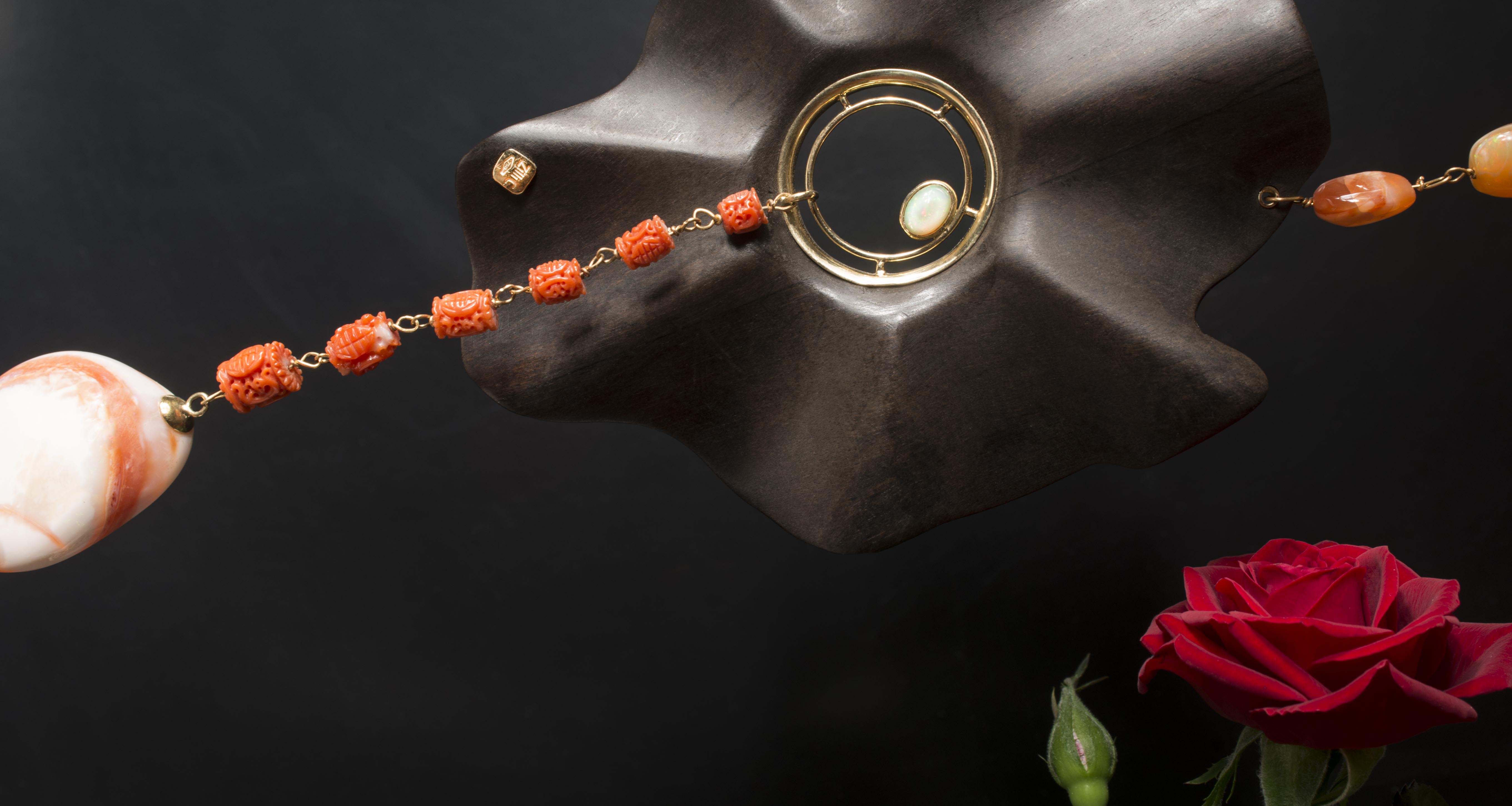 Collana in corallo, opali messicane legate in oro ed ebano. Ciondolo in corallo inciso e conchiglia opalizzata messicana.
