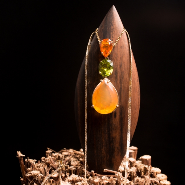 ART.36 - Navette in ebano con ciondolo di oplali di fuoco messicane tenute separate da un peridoto ovale, il tutto in oro giallo